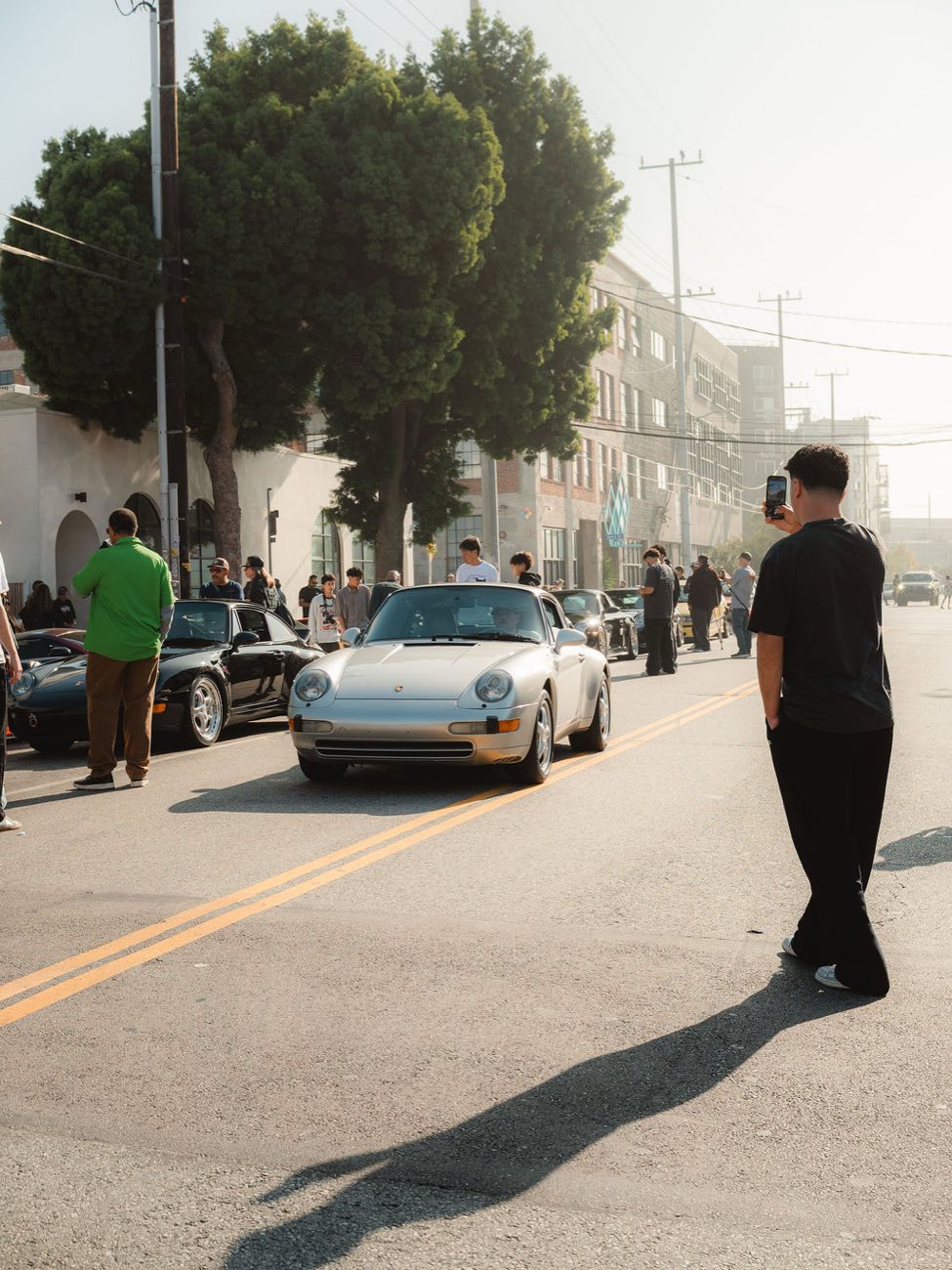 A silver Porsche 911 arriving at Morning Octane as attendees film