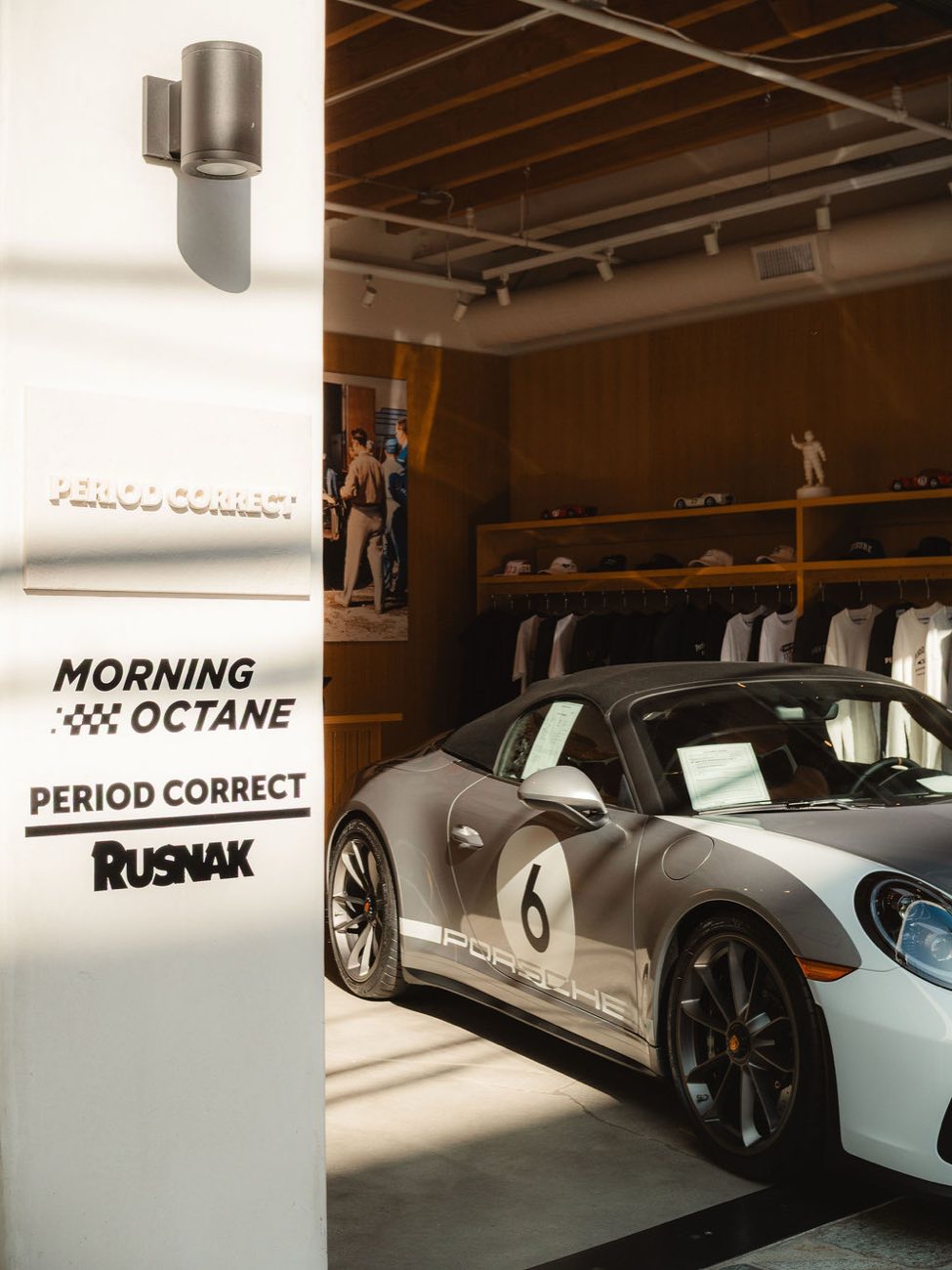 Morning Octane and Period Correct signage beside a Porsche 911 Speedster inside the Period Correct shop